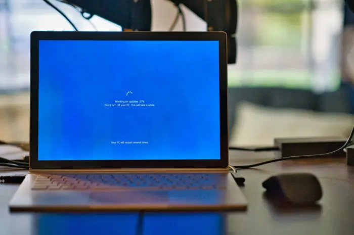 A laptop on a desk part way through a system update.